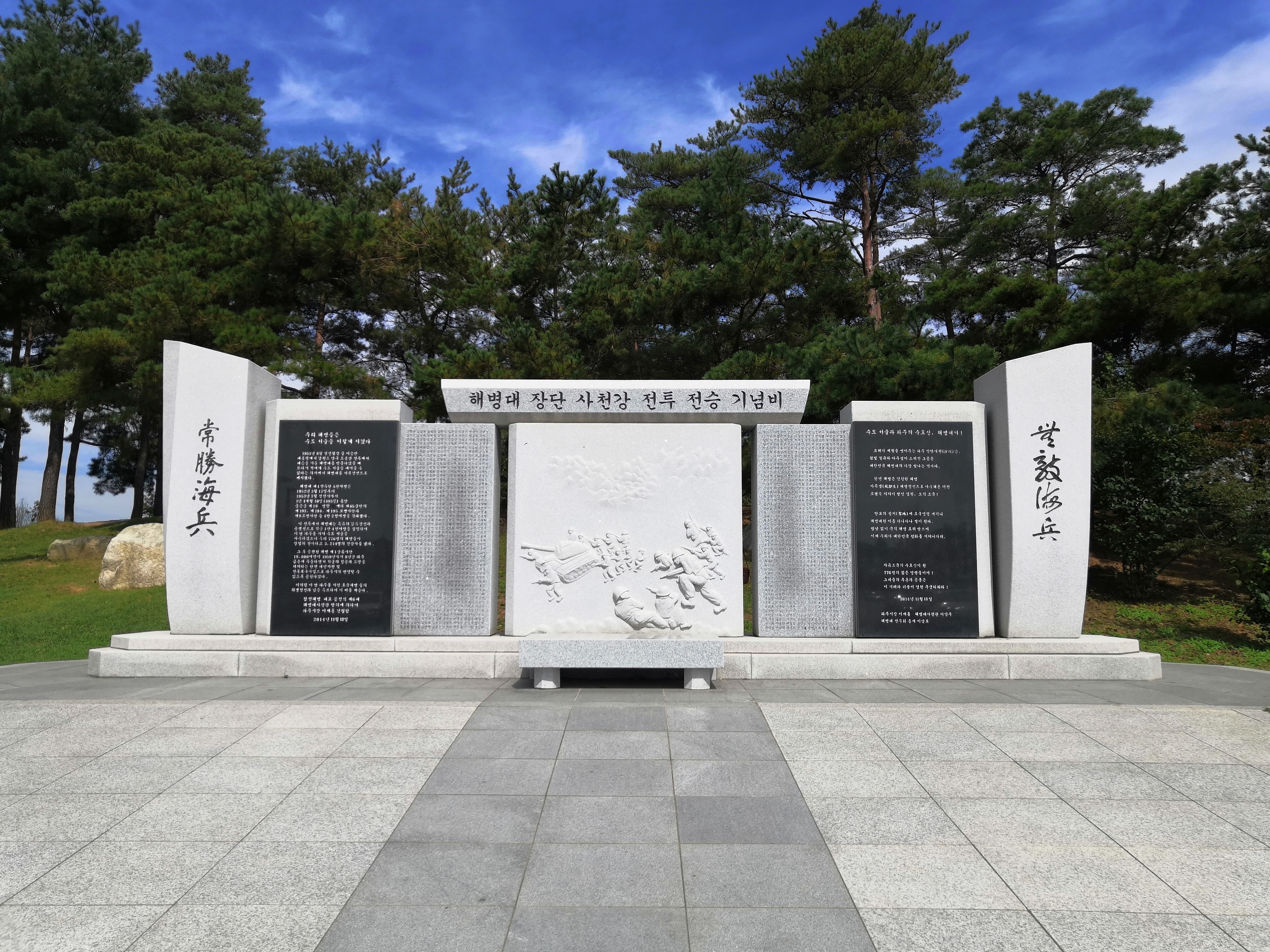 和平钟特写，钟体在蓝调天空下显得庄重肃穆。
